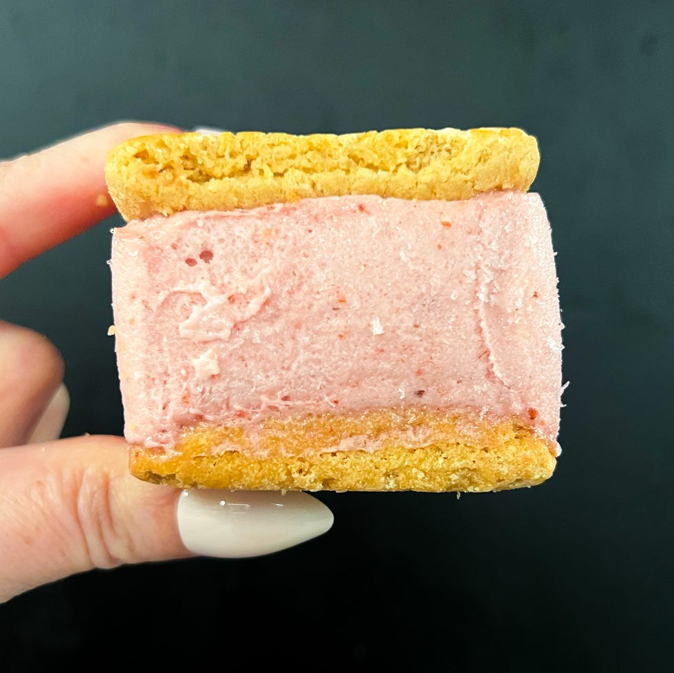 a handheld dessert sandwich with a pink filling and golden cookie edges