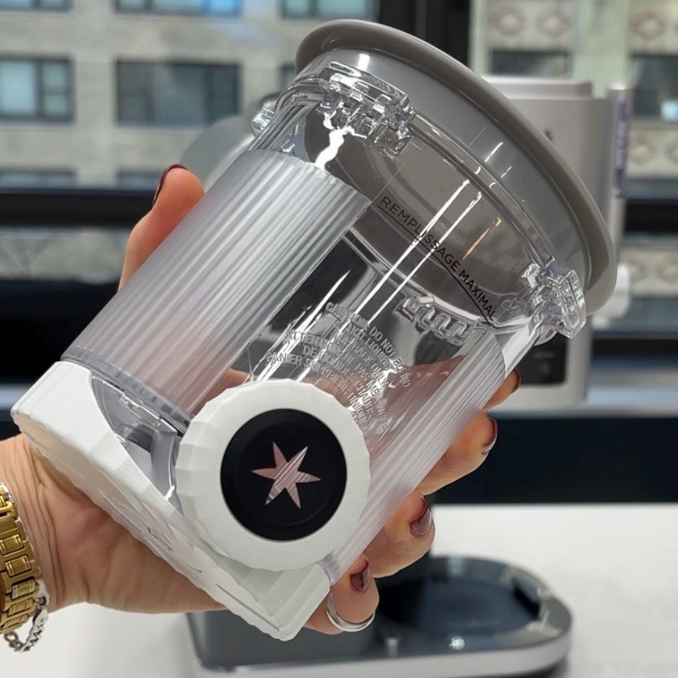 a transparent container with a white base featuring a round dial used for measuring or dispensing