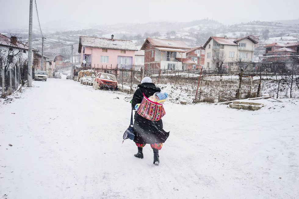 Een Pomaakse vrouw in Ribnovo draagt haar baby in de sneeuw