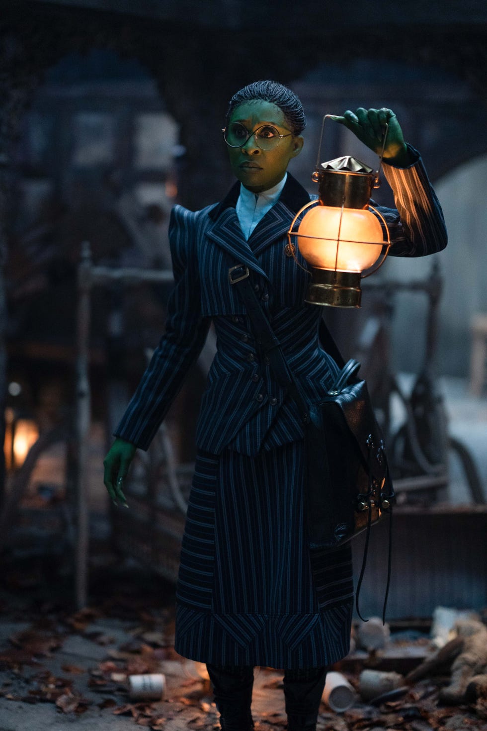 a figure in a striped suit holding a lantern in a dimly lit environment