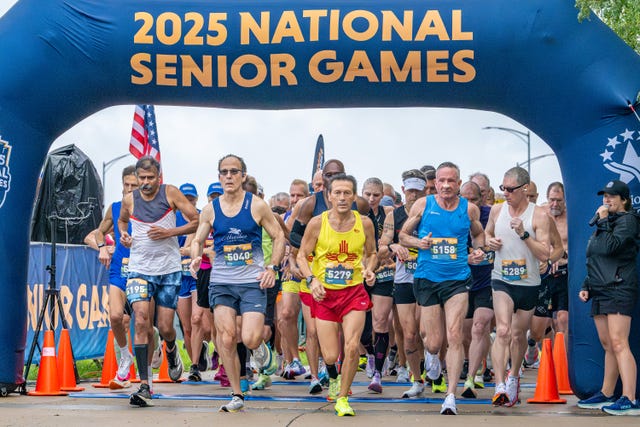 a group of runners start a race with a banner reading 2025 national senior games