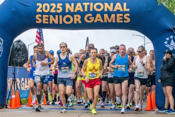 a group of runners start a race with a banner reading 2025 national senior games