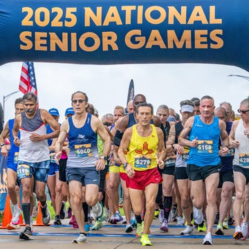 a group of runners start a race with a banner reading 2025 national senior games a group of runners start a race with a banner reading 2025 national senior games