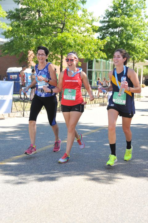 Three happy runners finishing a marathon