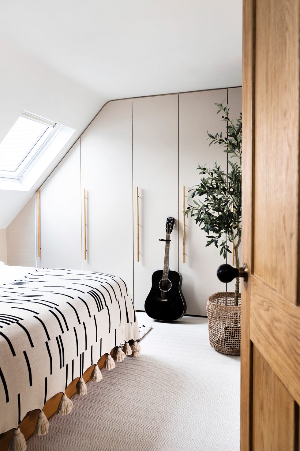 main bedroom in a loft extension with built in wardrobes in an off white shade