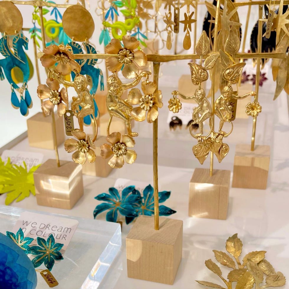 a set of gold earrings hanging on a rack