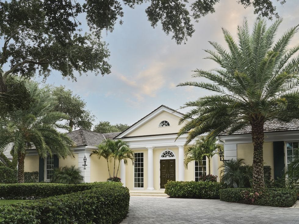 yellow house surrounded by palm trees