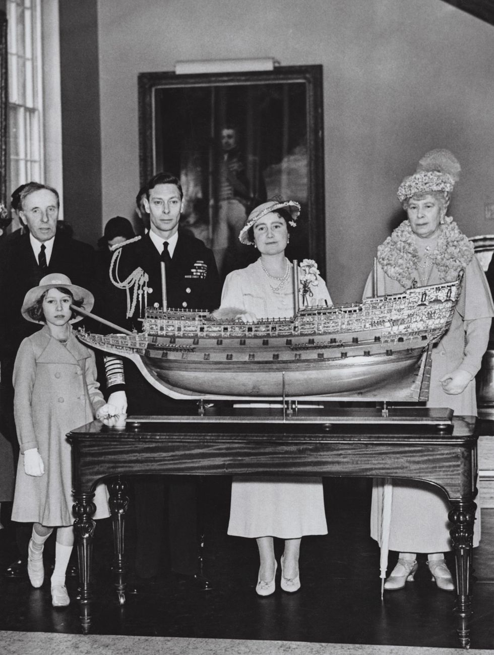 Ter gelegenheid van de opening van het National Maritime Museum in de Londense wijk Greenwich in 1937 poseren koning George VI koningingemalin Elizabeth koninginmoeder Mary en kroonprinses Elizabeth in 1937 voor een model van de Sovereign of the Seas