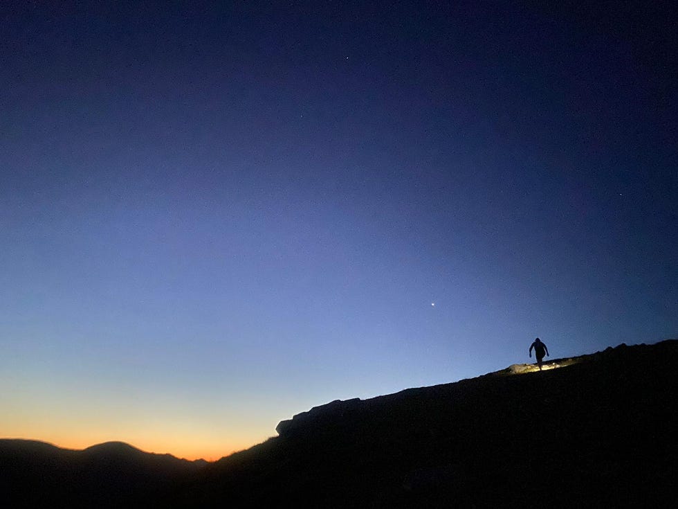 person running on a mountain in the dark