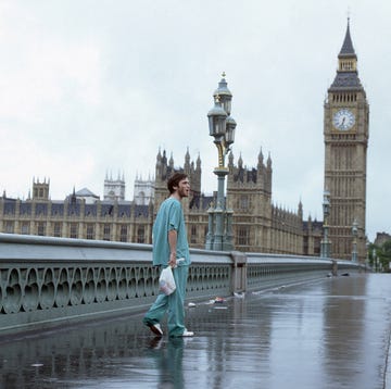 a person in scrubs walks alone on a wet bridge with big ben and the houses of parliament in the background a person in scrubs walks alone on a wet bridge with big ben and the houses of parliament in the background