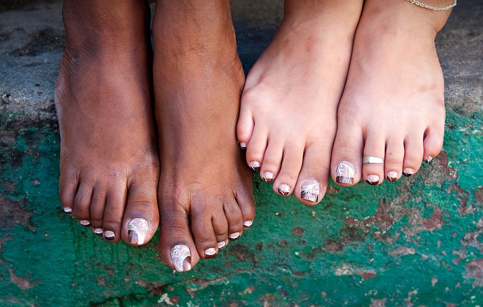 two pairs of feet with different skin tones.