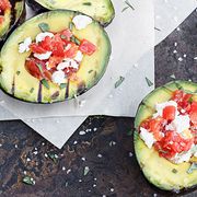 grilled avocado pieces topped with tomato and cheese