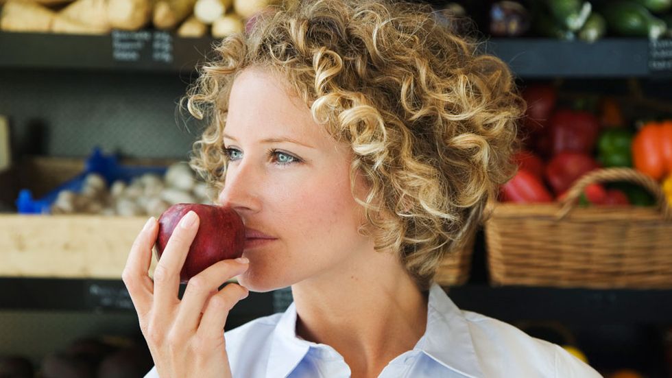 woman smelling apple
