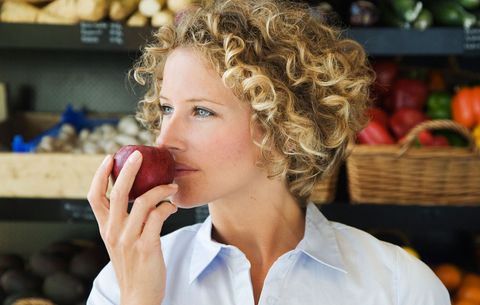woman smelling apple