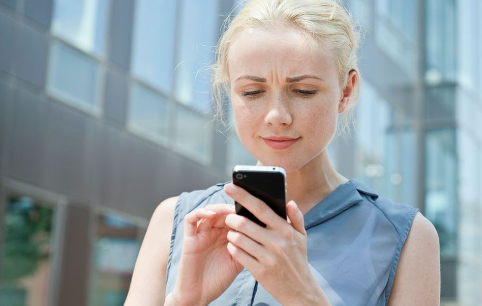 woman looking confused on her cell phone