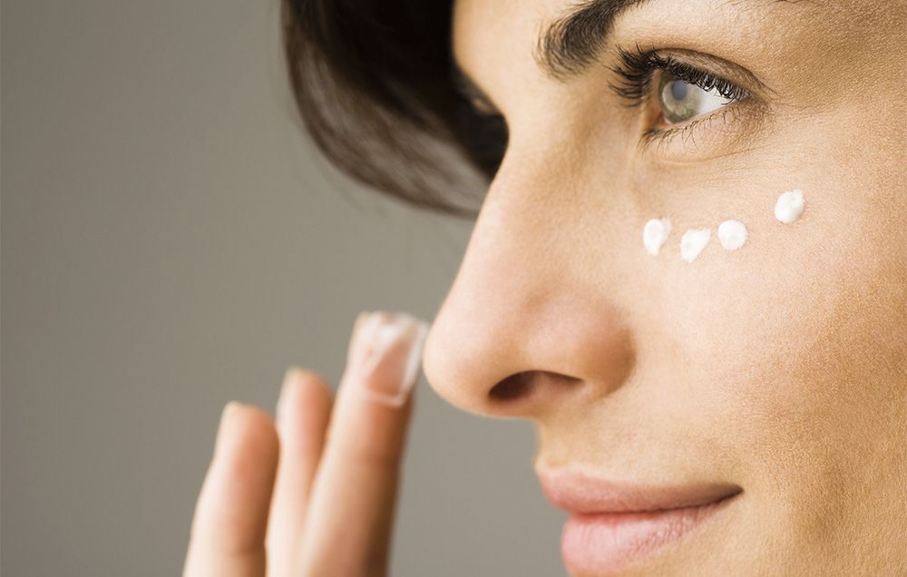 woman putting on concealer