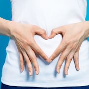 woman with hands on stomach heart shape