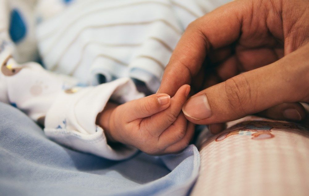 Holding hands with newborn
