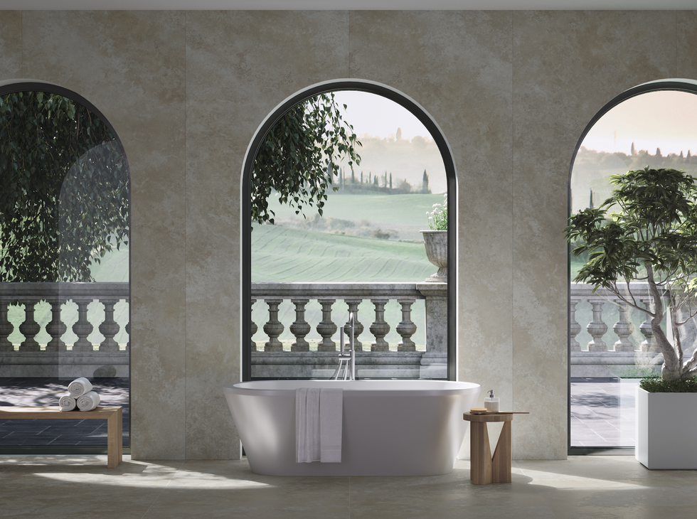 Modern bathroom with scenic views through large arched windows.