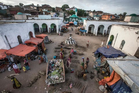 Mensen kopen en verkopen goederen op de vleesmarkt van Magala Gudo in Harar Ethiopi Hyenas bezoeken de markt elke nacht om zich te voeden met voedselresten uit de afvalcontainers