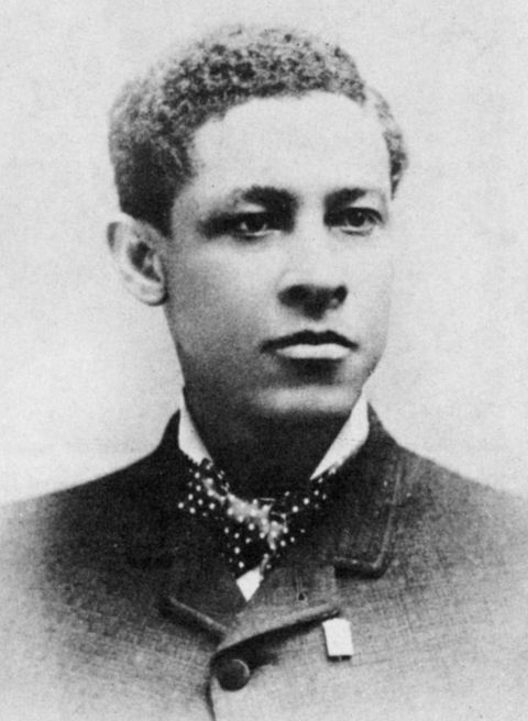 jan matzeliger in an old black and white photograph, he looks past the camera and wears a buttoned up suit jacket, polka dotted bow tie and light collared shirt