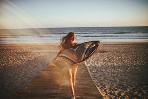 back view of girl walking on beach