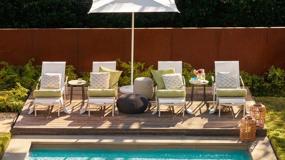 Outdoor lounging area by a pool with seating and decor elements.