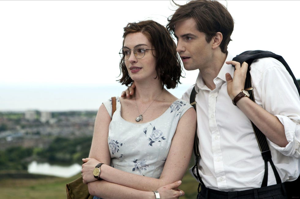 a couple embracing outdoors with urban scenery in the background