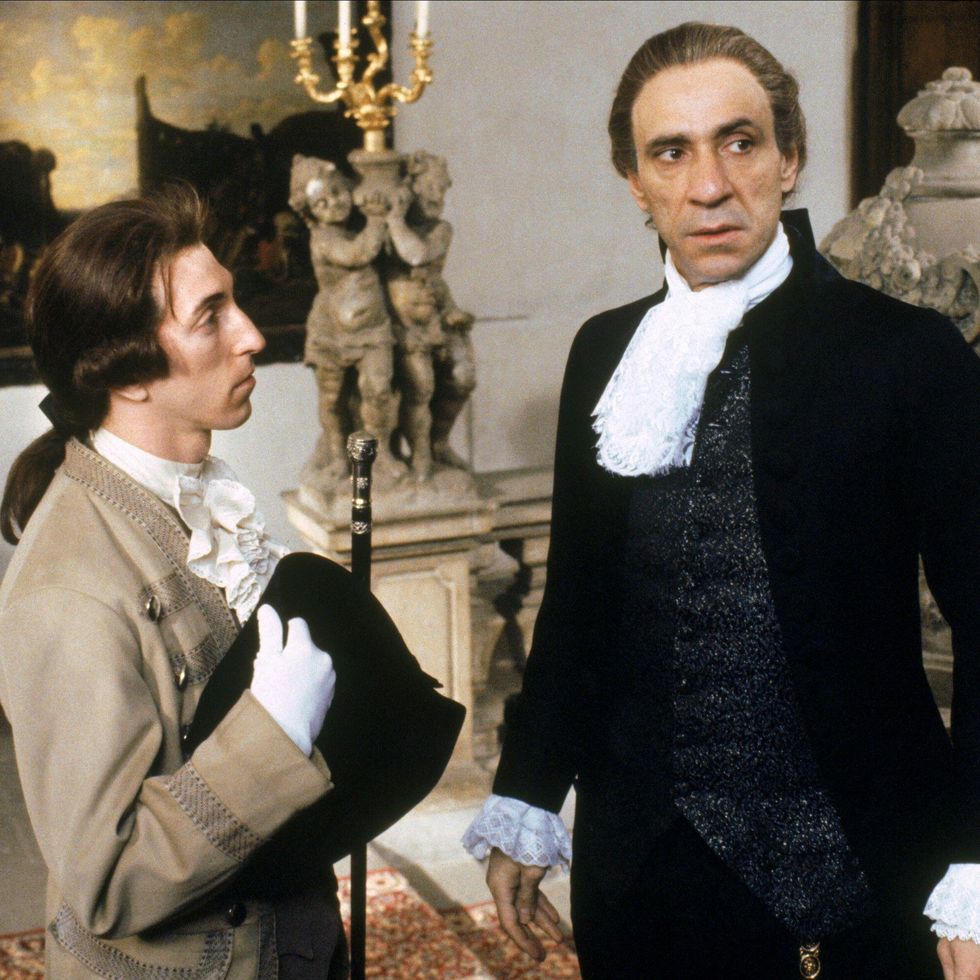 philip lenkowsky and f murray abraham in amadeus, they stand inside an ornately decorated room in dress clothes with ornate collars