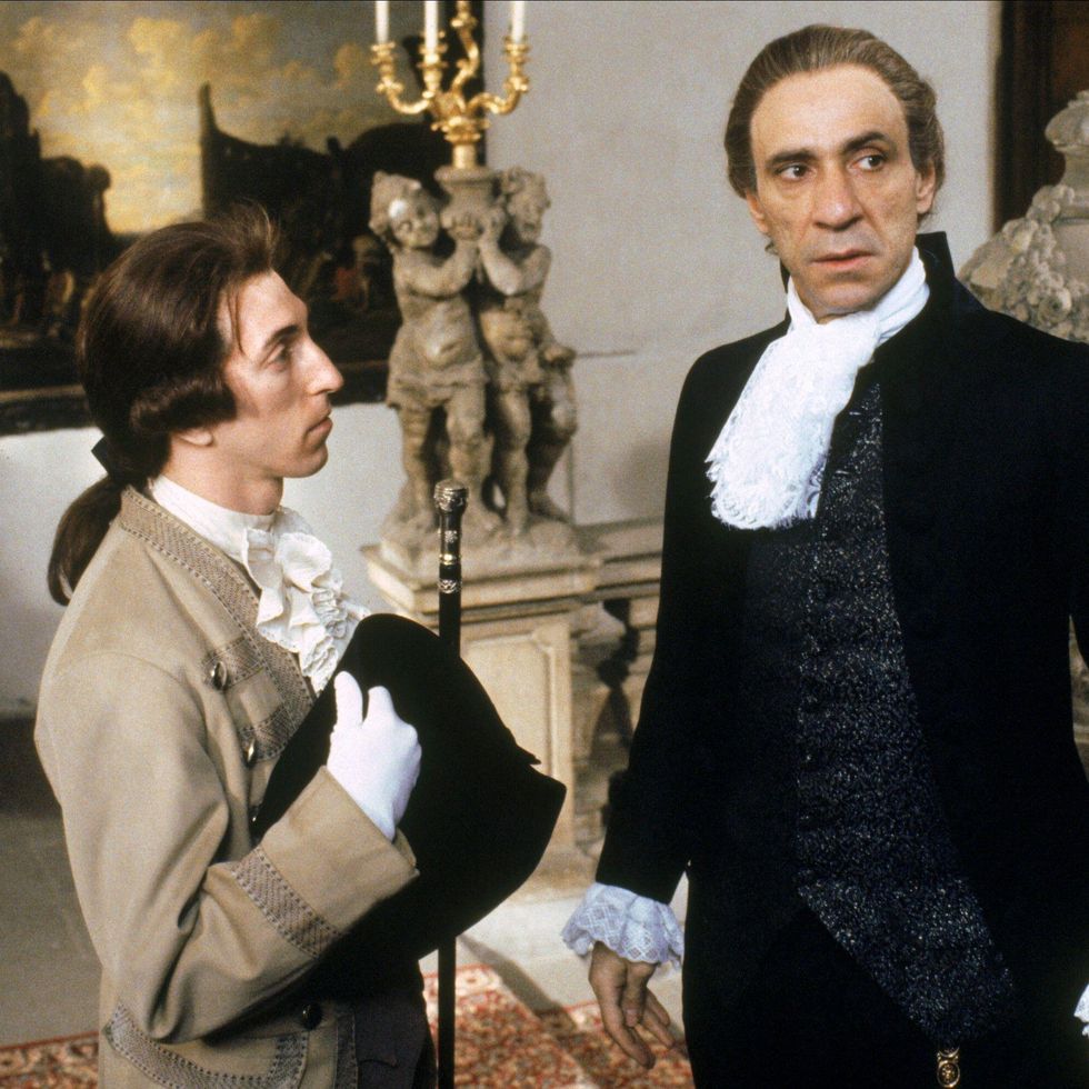 philip lenkowsky and f murray abraham in amadeus, they stand inside an ornately decorated room in dress clothes with ornate collars