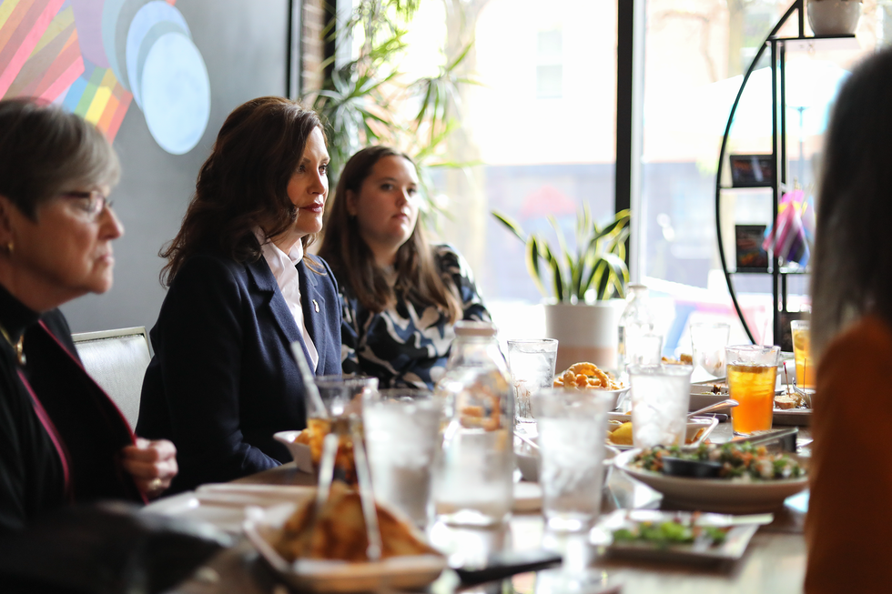 a group of people sitting around a table with food and drinks