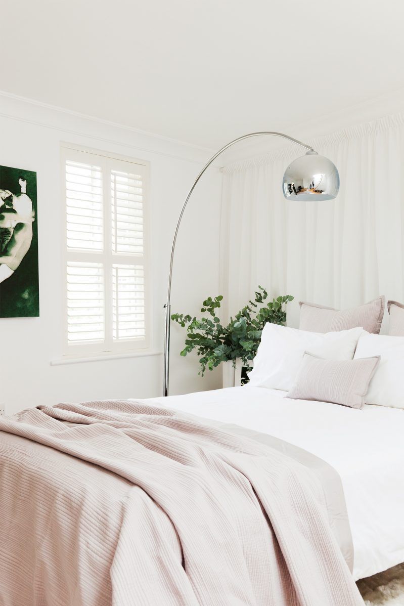 minimalist bedroom with metallic lamp