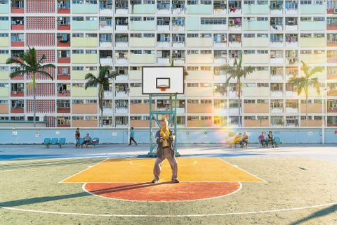 Deze foto werd gemaakt in een parkje binnen het woonblok Choi Hung in Hongkong Toen ik het parkje s middags bezocht was het vol jonge mensen die er fotos namen en basketbal speelden Maar toen ik hier bij zonsopgang kwam was het rustig en een heel andere plek Het parkje is in de vroege ochtend bestemd voor buurtbewoners en er heerste een gewijde sfeer Ik voelde goddelijkheid toen ik een oude man tai chi in de ochtendzon zag beoefenen