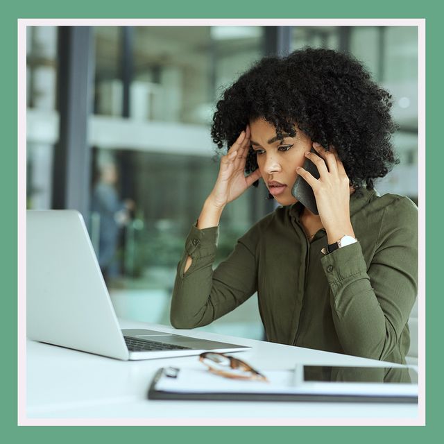 woman on computer and phone looking stressed