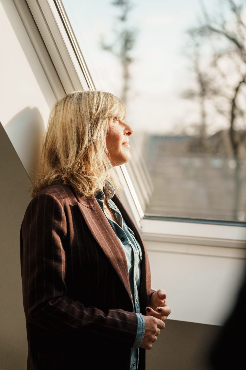 a woman looking out one of the velux roof windows in the factory house in muiden, the netherlands