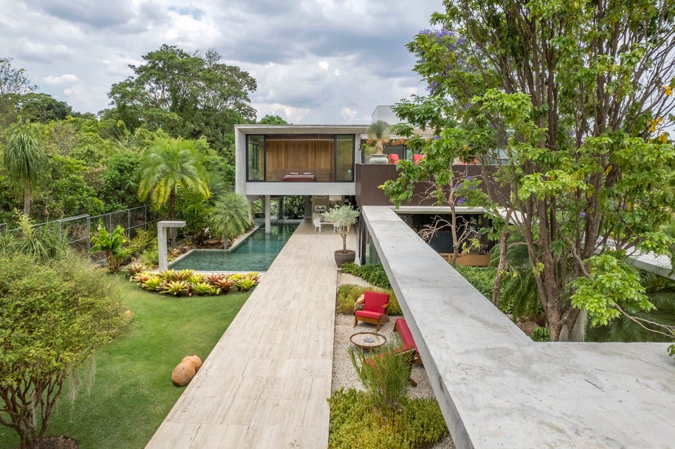 casa de hormigon con piscina que combina estructura brutalista, ventilacion cruzada y diseno tropical a medida