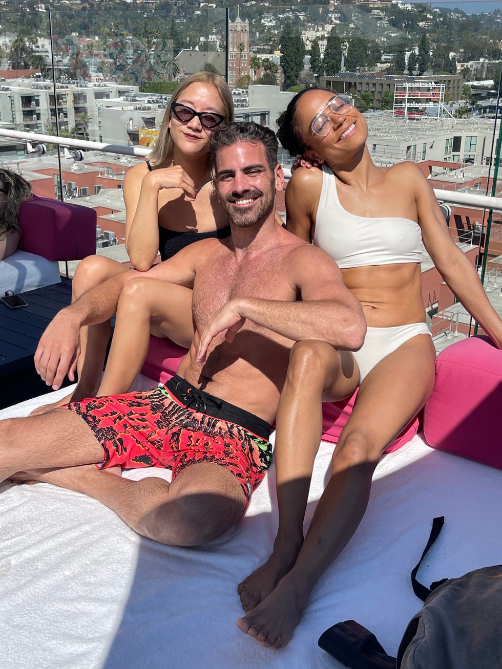 group of three individuals posing together on a rooftop lounge