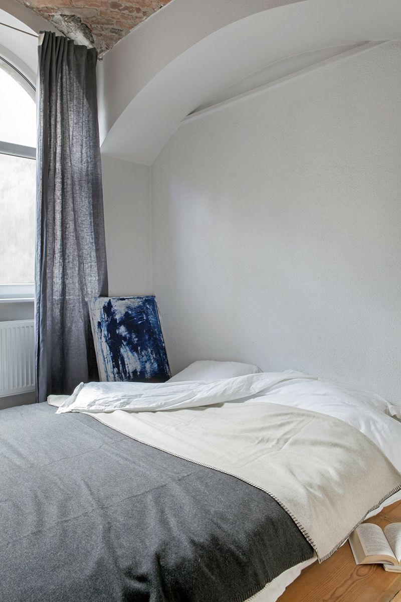 Vintage biało-szara sypialnia z oknem i niebieskim obrazem
