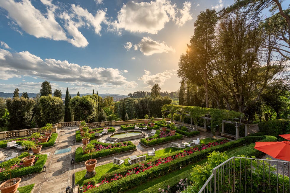 il salviatino hotel gardens with manicured hedges, flowers, and a vast expanse of cloudy sky