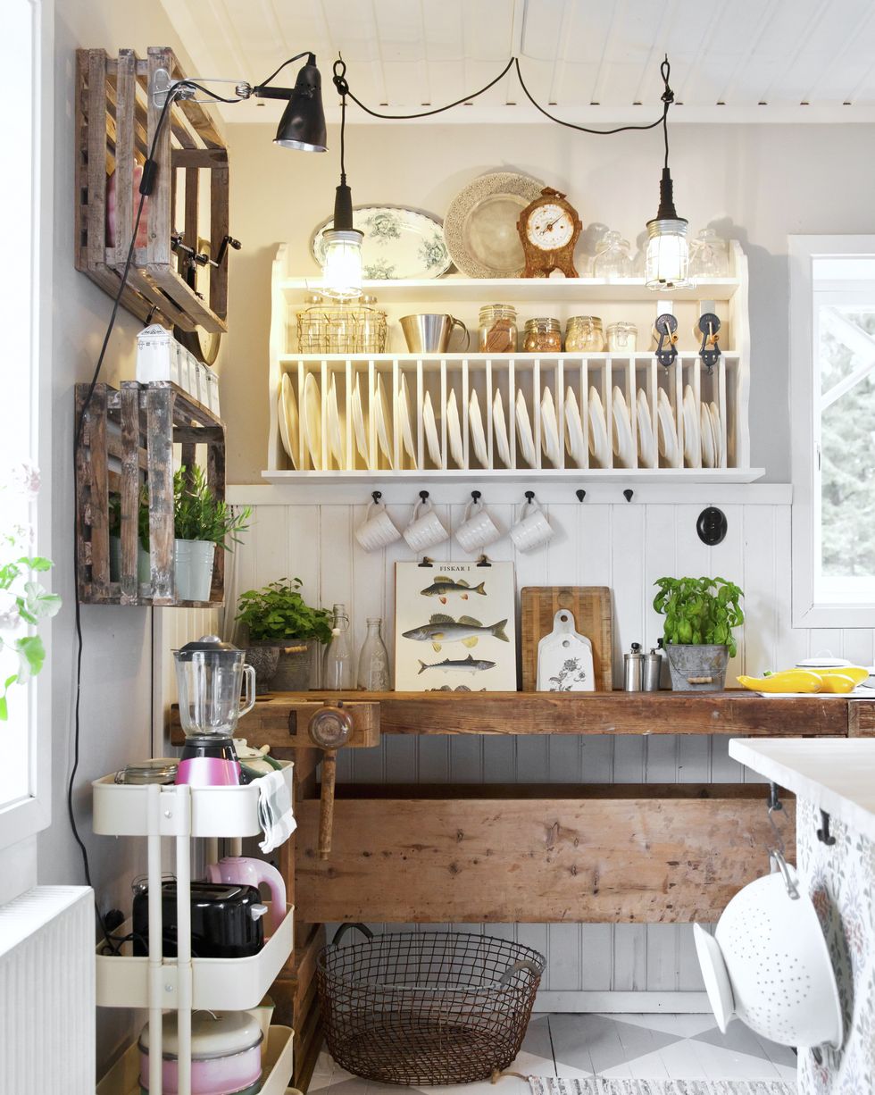 plate rack above old workbench in country house kitchen with quirky shelving made from old crates