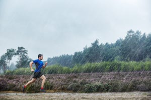 een man loopt hard in de regen