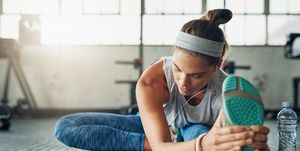 shot of a young woman stretching in a gym