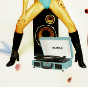 a woman poses over a record player between two planets