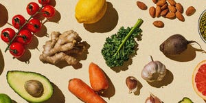 a variety on fruit vegetables and nuts laid out on a pale yellow background