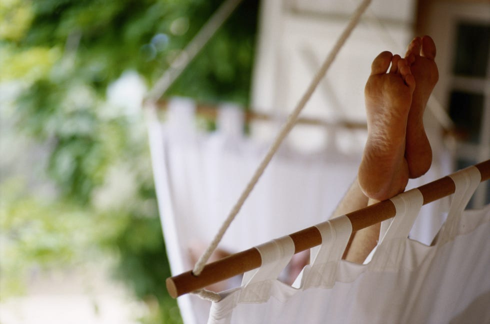 30s man relaxing in hammock, feet up