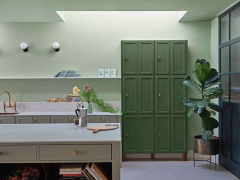 a kitchen with green walls and a green cabinet