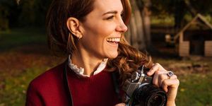 kate middleton smiling and holding a camera