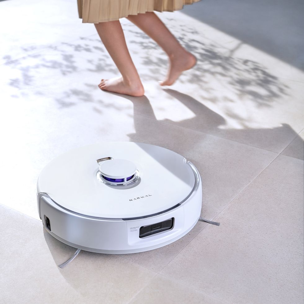 a person standing next to a toaster on a tile floor