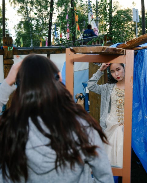 Een festivalganger in het dorp Amga heeft zich in traditionele dracht gestoken In veel gezinnen worden de kostuums voor de zomerfestiviteiten gezamenlijk voorbereid Moeders geven erfsieraden door aan hun dochters