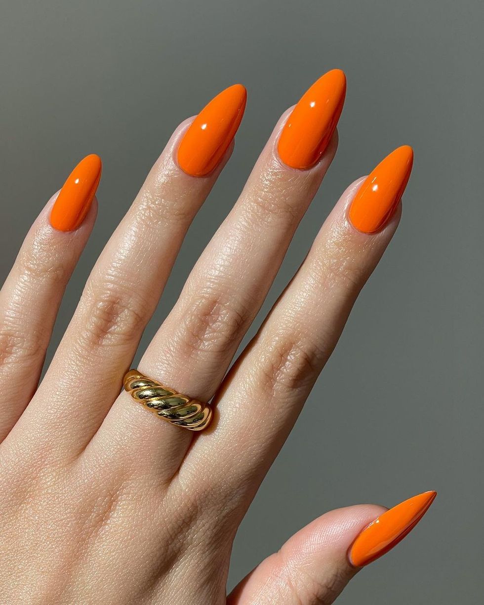 a hand with orange nails